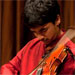 Two images of Ambi Subramaniam playing the violin