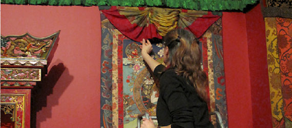 Exhibitions Conservator Jenifer Bosworth working on the installation of a thangka